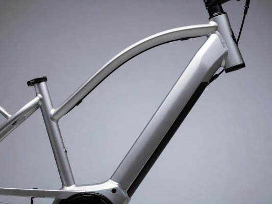Professional realistic photograph: Close up view of the real low top tube design on a genuine step-through electric bicycle frame. Accurate frame geometry, authentic materials, natural daylight, no AI artifacts.